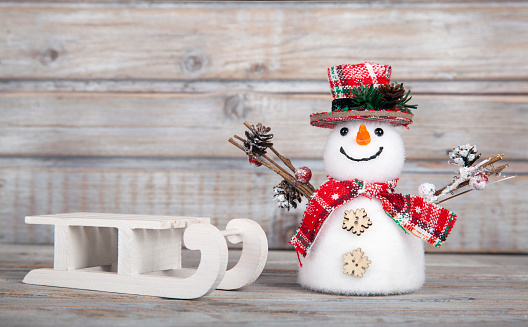 Christmas decorative snowman on white rustic wooden background.