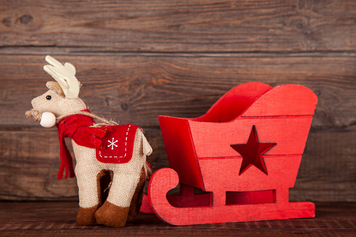 Christmas decorative wooden Santa's sleigh on rustic wooden background.