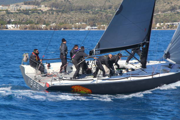 segelboote segeln bei windigem wetter im blauen wasser der ägäis - sailboat storm teamwork competition stock-fotos und bilder