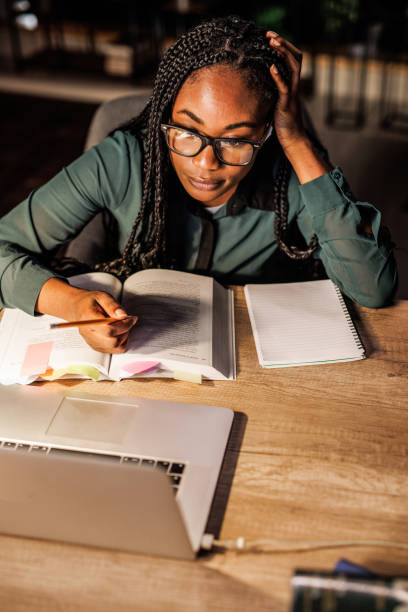 istock Tired female student taking notes and studying at her desk late at night 1821234034
