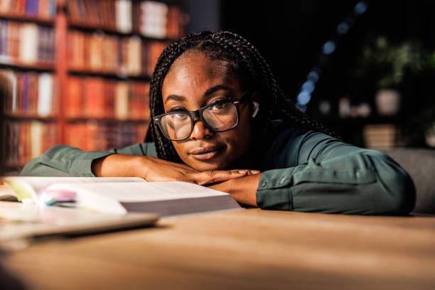 istock Tired university student leaning against her desk when studying for a long time late at night 1821234356