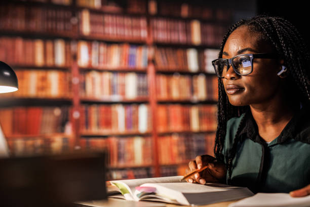 istock Diligent university student studying for exam at the library late at night 1821234358