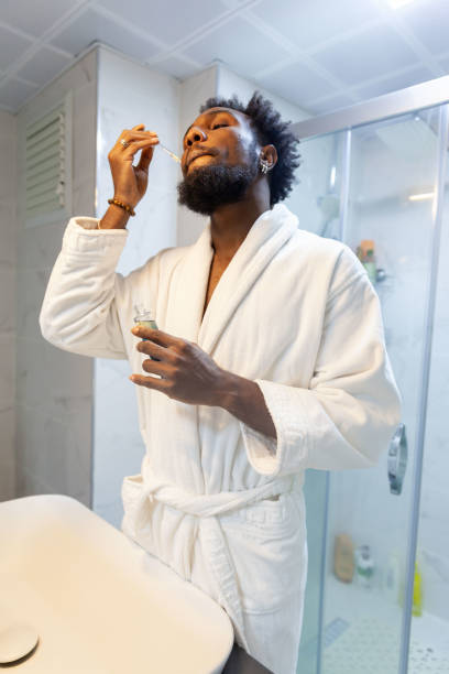 istock Afro man holding facial serum 1821263982