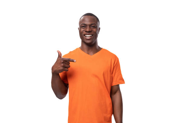 istock young successful charismatic american man dressed in basic orange t-shirt points with index finger on white background with copy space 1821267566