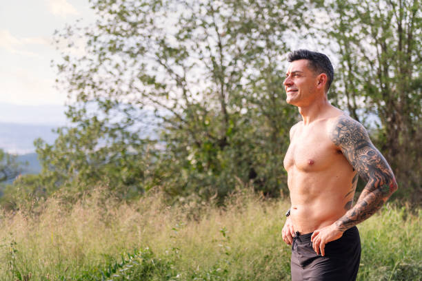 homme avec le corps de remise en forme souriant à la campagne - male torso abdominal muscle the human body photos et images de collection