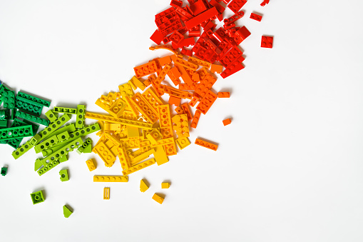 Colorful rainbow plastic toy bricks blocks on white background. Education concept. Copy space.