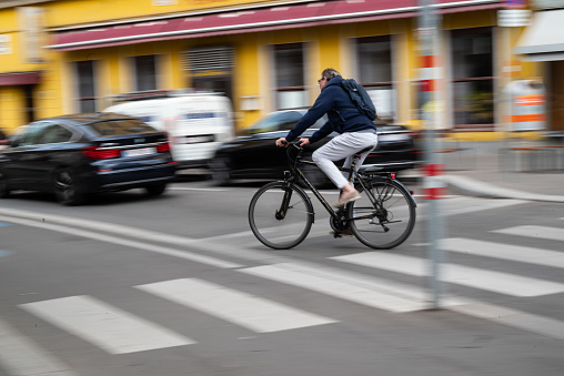 Vienna, Austria. 29 September 2023. Man riding his bike fast in Favoriten Street - motion blur effect showing speed