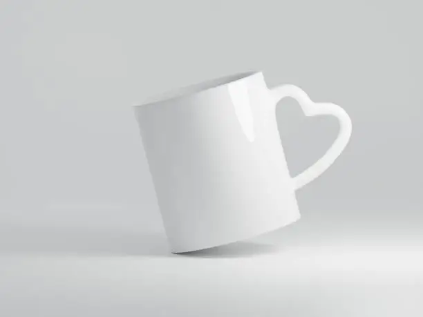 Photo of White Heart Shaped Handle Ceramic Mug Floating on a Plain White Background