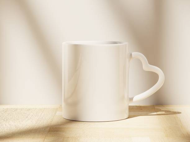 istock White Heart Shaped Handle Ceramic Mug Sitting on a Wooden Floor with Soft Window Shadows 1821452481
