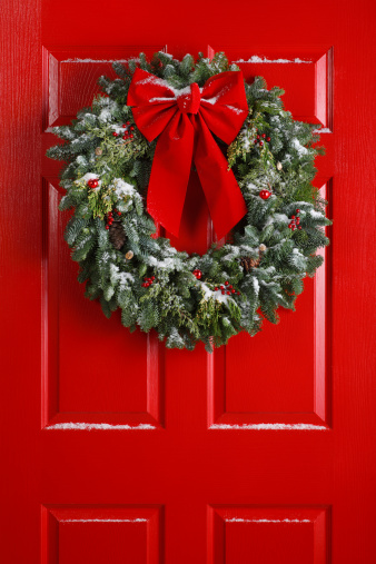 A Christmas wreath hanging on a red door.To see more holiday images click on the link below: