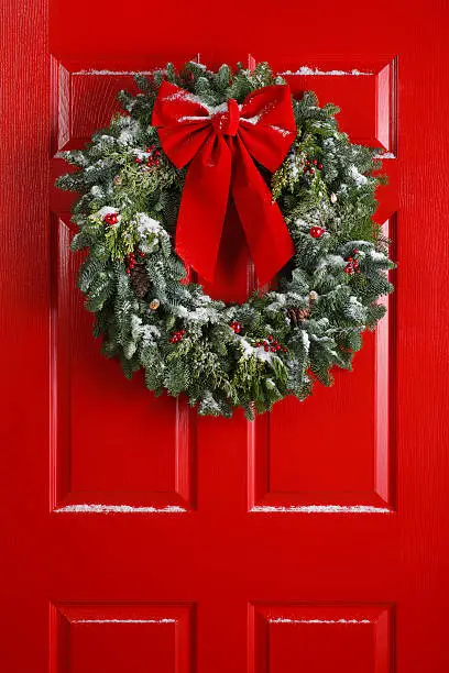 A Christmas wreath hanging on a red door.To see more holiday images click on the link below:
