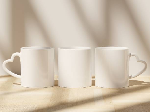 istock Three Heart Shaped Handle Ceramic Mugs on Wooden Floor with Soft Shadows from Window 1821452991