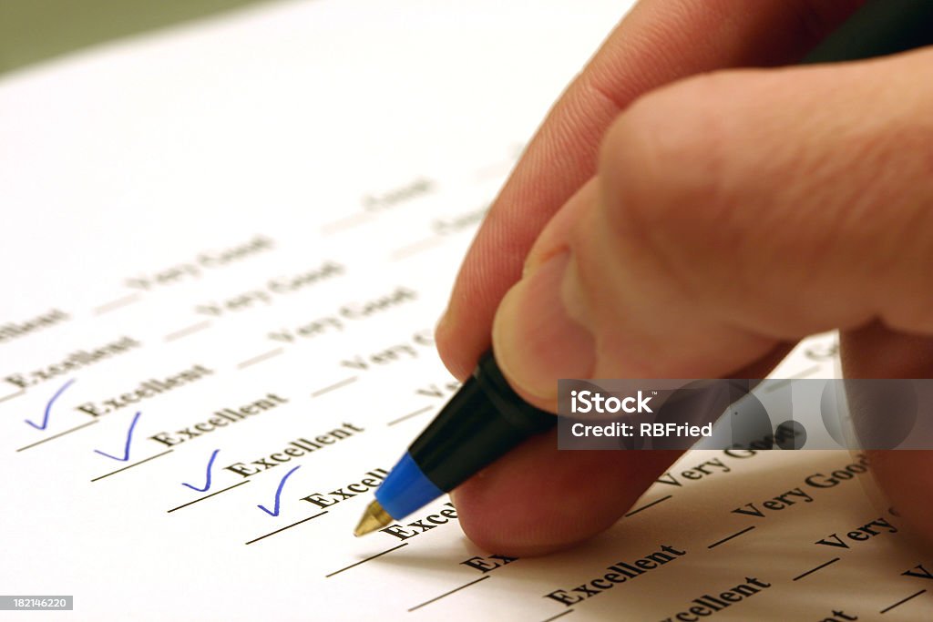 Person sitting in a survey ticking excellent a man taking a survey, giving great feedback Report Card Stock Photo