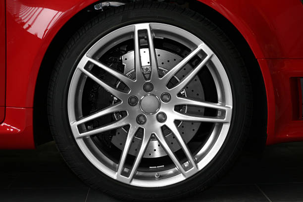 легкосплавный диск колеса на красный спортивный автомобиль - wheel alloy alloy wheel tire стоковые фото и изображения
