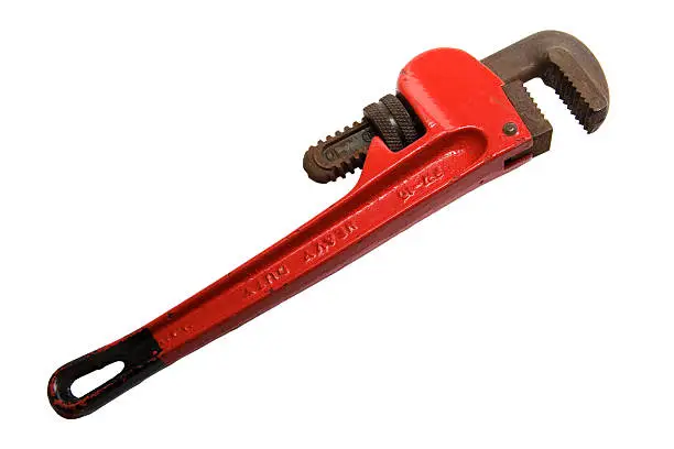 Photo of Red adjustable pipe wrench laying on a white background