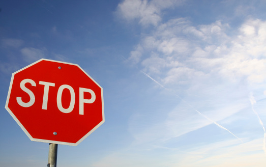 A selective focus image of a no entry road sign against a blurred building.