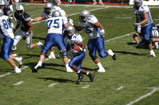 Young football player rushing for a touchdown