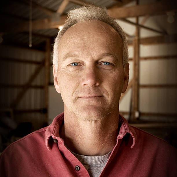 Man facing camera with interior of barn as the background stock photo