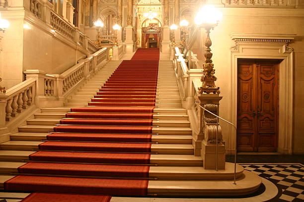 Red carpet cascading down a grand staircase stock photo