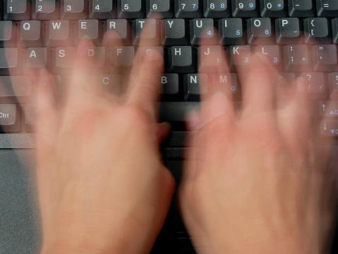 A slow shutter speed was used to capture the speed of the typist's fingers.