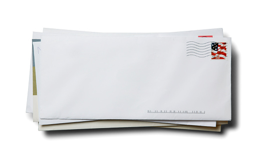 A stack of blank business envelopes with a cancelled U.S. flag stamp isolated on a white background with a soft shadow.