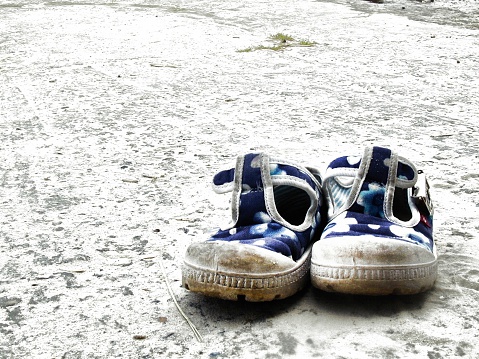 Close-up of old and dirty canvas tennis shoes, isolated on white.