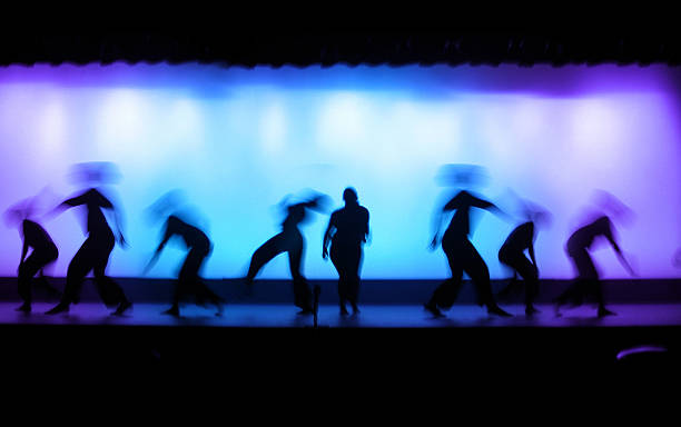 Dance Theater Shot of performers on stage with lights in the background.Other Night Images: ballerina shadow stock pictures, royalty-free photos & images