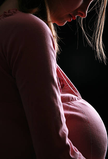 Pregnant caucasian woman touching her belly. Silhouette view