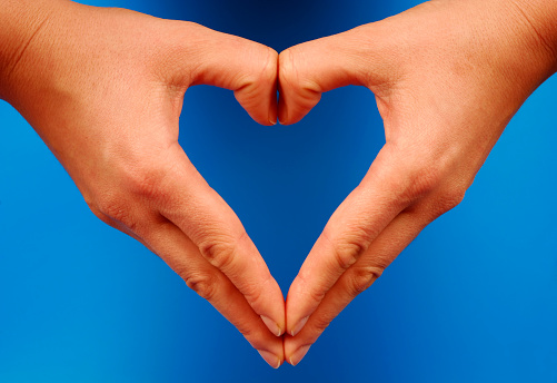 Hands forming a heart on a blue background