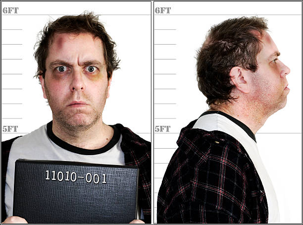 Mugshot - Computer Crime "Police mugshot of a criminal. Badly bruised and battered. Binary sequence criminal identification number added to represent ""Computer Crime""" prisoner photos stock pictures, royalty-free photos & images