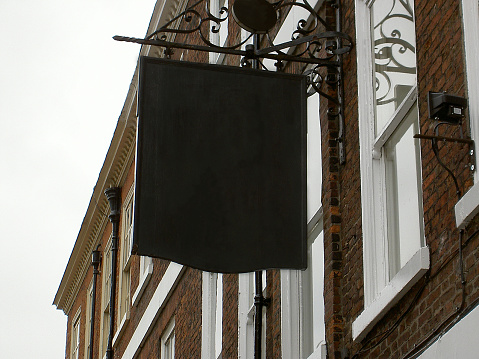 Blank English pub sign hanging from wall