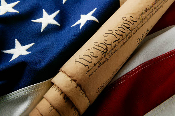 We the People 7 A rolled up copy of the United States Constitution sitting on an American flag. revolution photos stock pictures, royalty-free photos & images