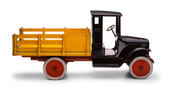 Antique toy truck on white surface with soft shadow