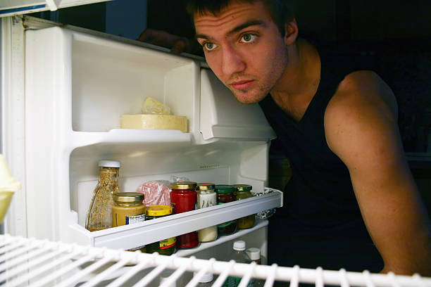 istock Man searching for food in a refrigerator 182148736