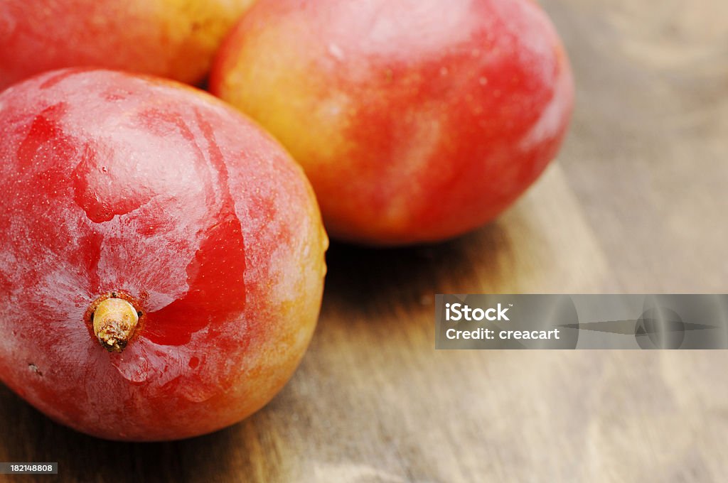 Maturo mangos contro quercia scura, poco profondo fuoco - Foto stock royalty-free di Alimentazione sana