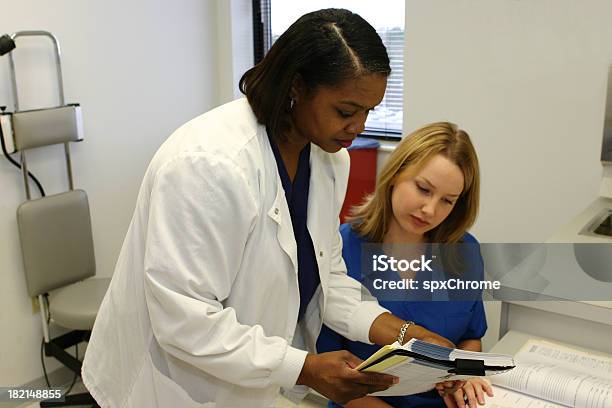 Dwie Pielęgniarki Patrząc Na Schemat Medyczny - zdjęcia stockowe i więcej obrazów Akta - Akta, Biuro, Biznes