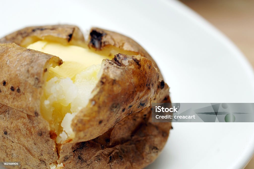 Giacca al forno di patate con burro su piatto - Foto stock royalty-free di Alimentazione sana