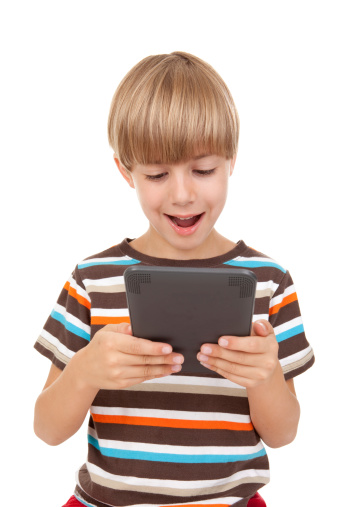 An adorable 7 year old boy enjoying an electronic game.