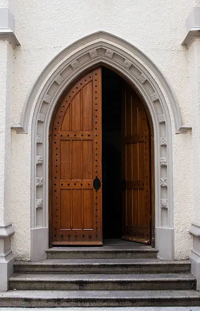Photo of Wooden door half open on a medieval style building entrance