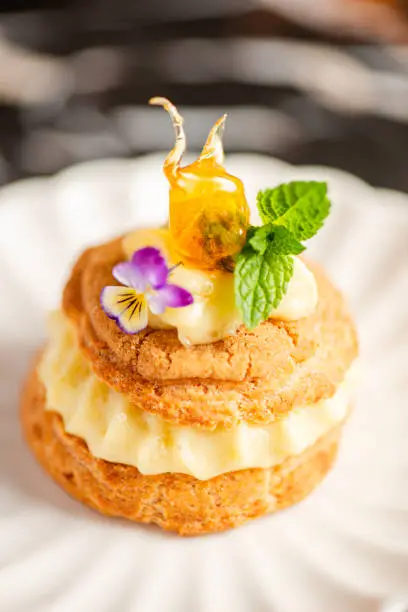 Freshly baked pistachio cream puff with craquelin filled with pastry cream and praline.