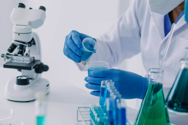 istock Medical Development Laboratory: Caucasian Female Scientist Looking Under Microscope, Analyzes Petri Dish Sample. Specialists Working on Medicine, Biotechnology Research in Advanced Pharma Lab 1821504720