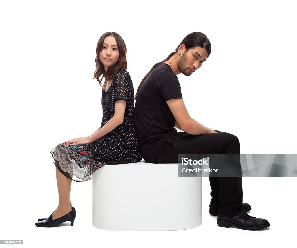 Relationship problems: young japanese couple Young japanese couple sitting back to back. White background. Fashion Model Stock Photo