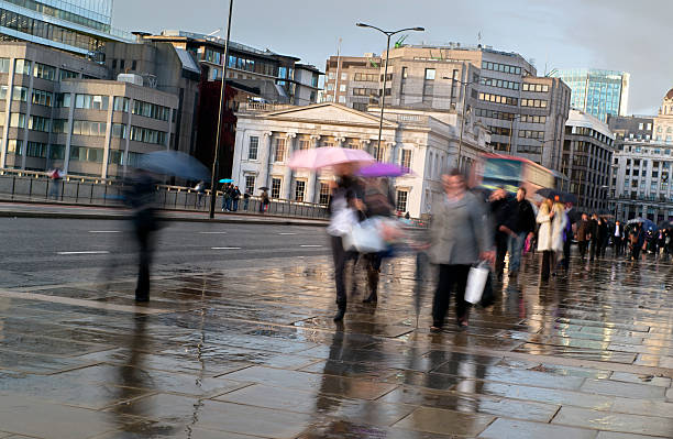 istock Commuters in the rain walking with umbrellas 182151690