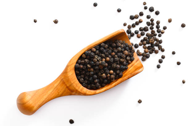 Scoop of Peppercorns Black peppercorns isolated in a wooden scoop black peppercorn photos stock pictures, royalty-free photos & images