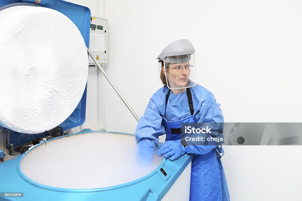 Recipiente con líquido nitrogen.doctor en traje de trabajo hazmat - Foto de stock de Asistencia sanitaria y medicina libre de derechos