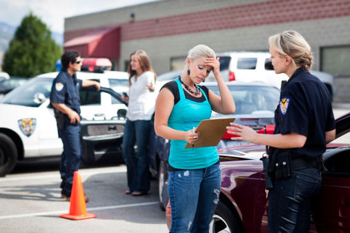 A stock photo of two police officers responding to a traffic accident involving two young women.