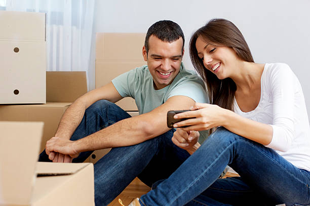 istock Couple Moving House relaxing with smart phone 182153370