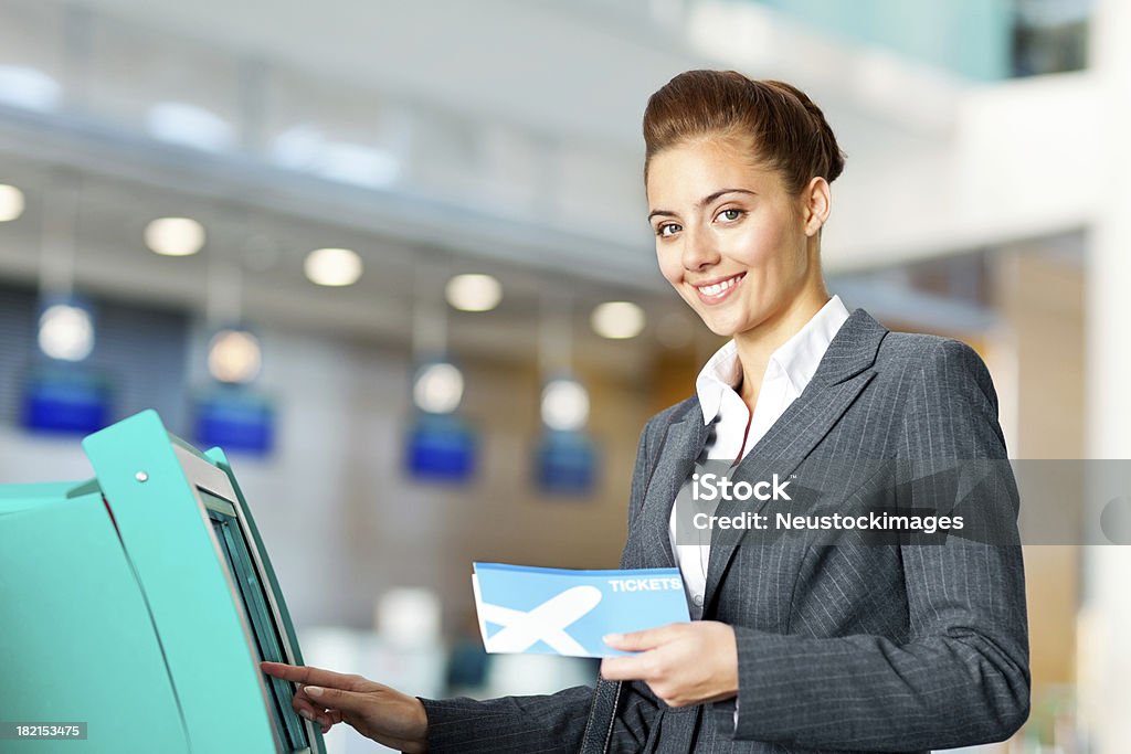 Femme d'affaires qui s'enregistrent à l'aéroport - Photo de Stand commercial libre de droits