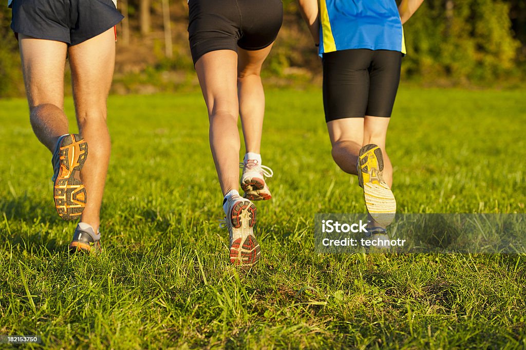 Tres atletas corriendo en el prado - Foto de stock de Aerobismo libre de derechos