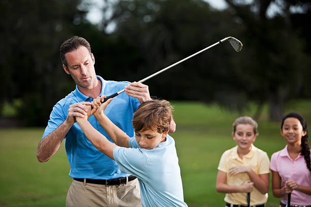 golf instructor anpassen jungen griffigkeit - playing golf fotos stock-fotos und bilder